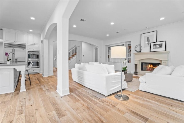 living room with light hardwood / wood-style floors and crown molding