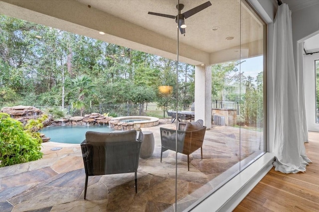 view of patio / terrace with ceiling fan and a swimming pool with hot tub