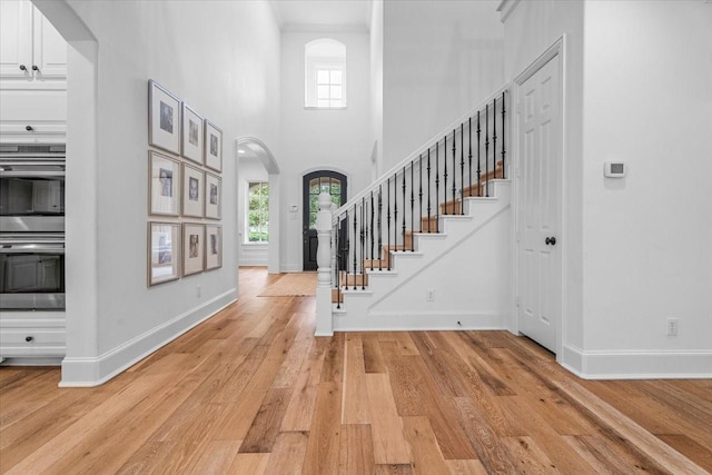 foyer entrance with light hardwood / wood-style flooring and a high ceiling