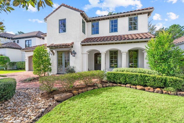 mediterranean / spanish house with a front lawn and a garage