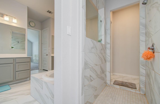 bathroom featuring vanity and independent shower and bath