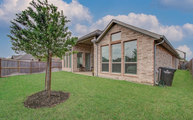 rear view of house featuring a yard and a patio