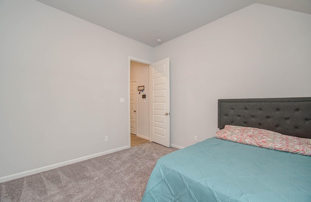 bedroom with lofted ceiling and light carpet