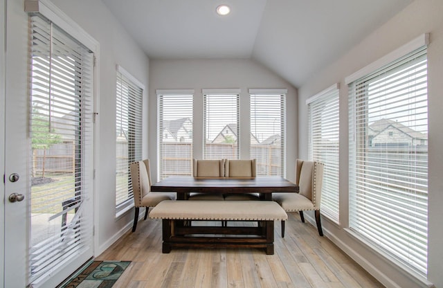 dining room with plenty of natural light, light hardwood / wood-style floors, and vaulted ceiling