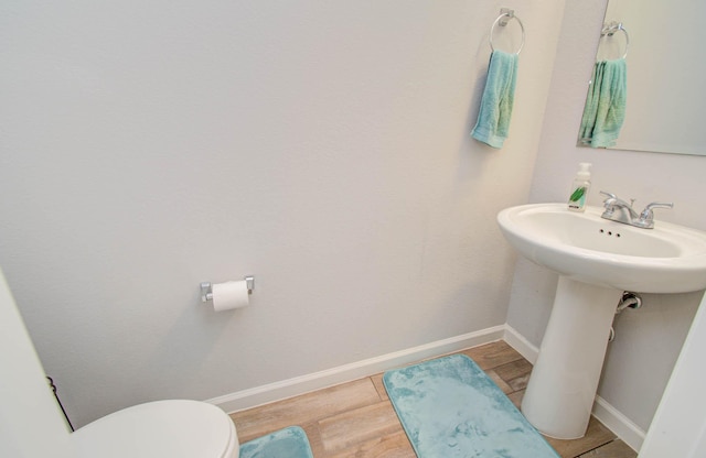 bathroom featuring hardwood / wood-style floors and toilet