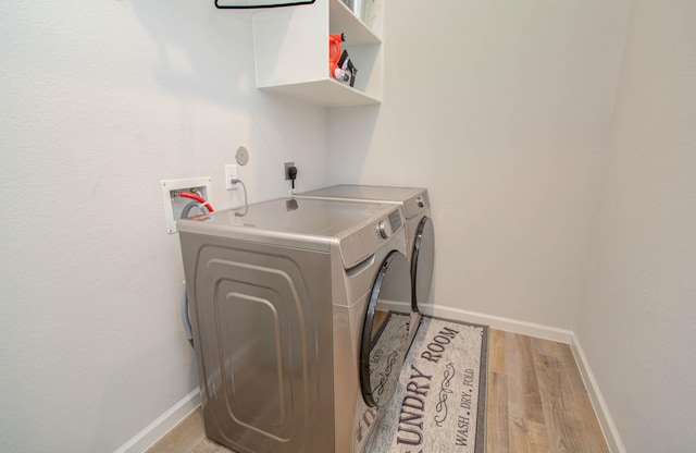 clothes washing area with light hardwood / wood-style flooring and washing machine and clothes dryer