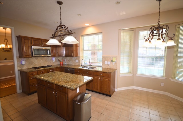 kitchen featuring tasteful backsplash, stainless steel appliances, sink, pendant lighting, and a center island