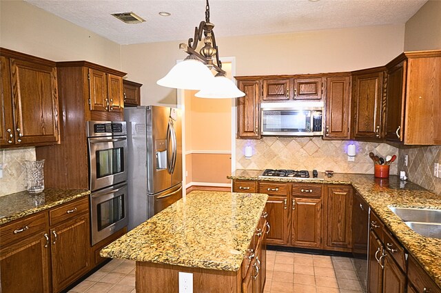 kitchen with backsplash, a center island, decorative light fixtures, and appliances with stainless steel finishes