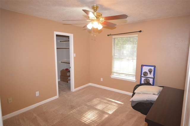 living area featuring light carpet, ceiling fan, and a textured ceiling