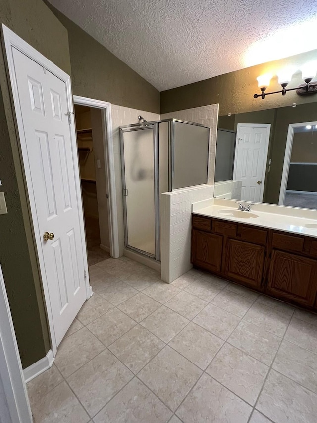 bathroom featuring lofted ceiling, vanity, an enclosed shower, tile patterned floors, and a textured ceiling