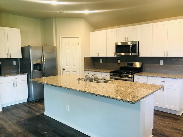 kitchen with white cabinets, appliances with stainless steel finishes, dark hardwood / wood-style flooring, and decorative backsplash