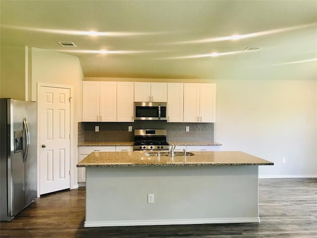 kitchen with white cabinets, appliances with stainless steel finishes, and an island with sink