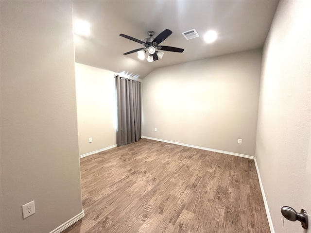 spare room with ceiling fan, vaulted ceiling, and hardwood / wood-style flooring