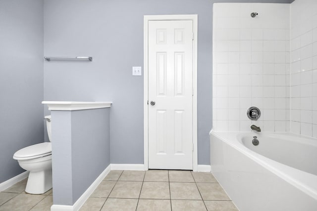 bathroom featuring toilet, tile patterned floors, and tiled shower / bath