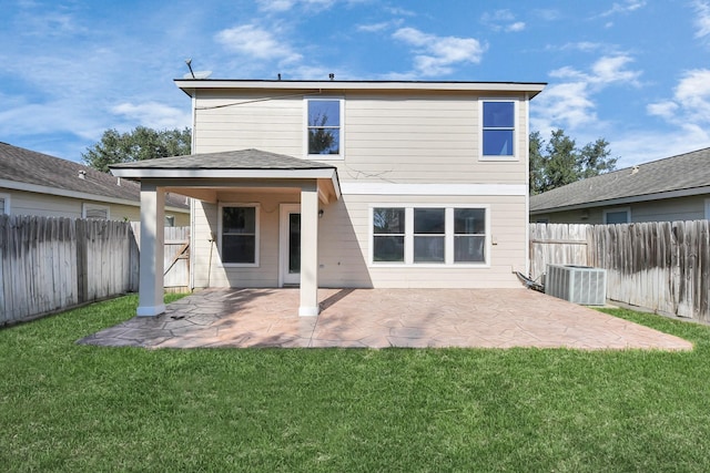 rear view of house with central AC unit, a patio area, and a lawn