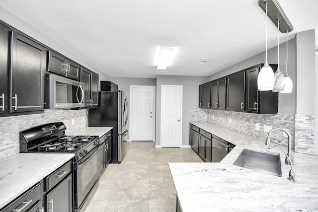 kitchen featuring sink, hanging light fixtures, light stone countertops, tasteful backsplash, and stainless steel appliances