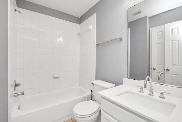 full bathroom featuring vanity, tiled shower / bath combo, and toilet