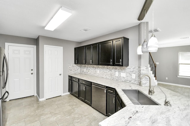 kitchen featuring hanging light fixtures, sink, decorative backsplash, light stone countertops, and appliances with stainless steel finishes