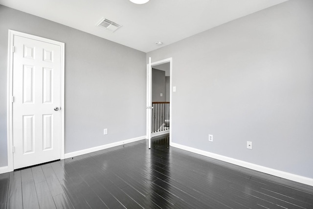 empty room with dark hardwood / wood-style flooring