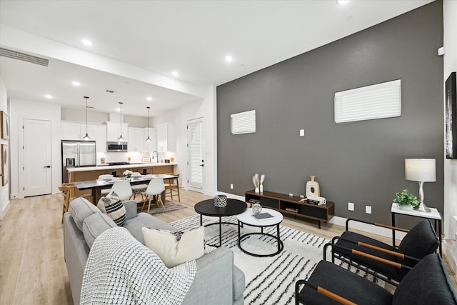 living room featuring light hardwood / wood-style flooring and sink