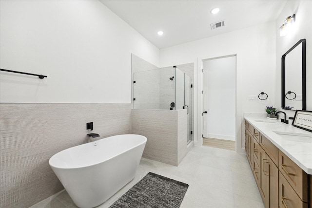 bathroom featuring vanity, tile walls, and independent shower and bath