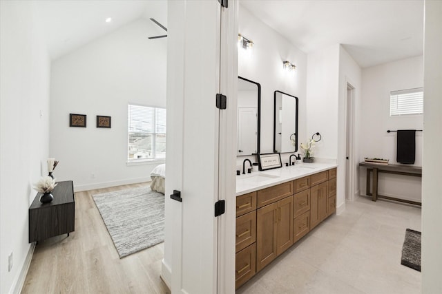 bathroom featuring vanity, wood-type flooring, and high vaulted ceiling