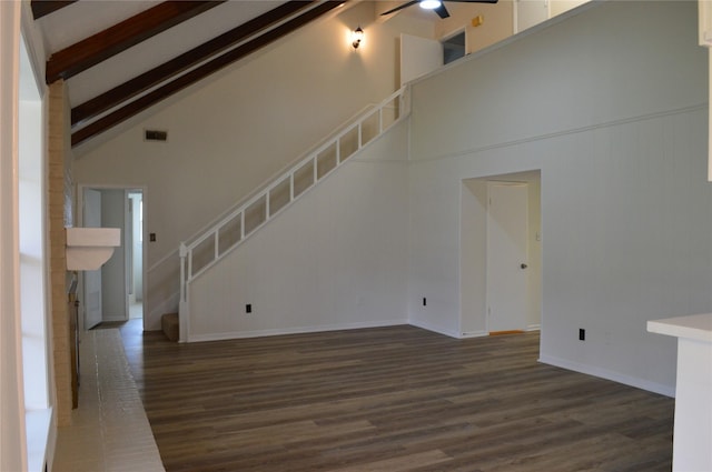 unfurnished living room with ceiling fan, beam ceiling, dark hardwood / wood-style flooring, and high vaulted ceiling