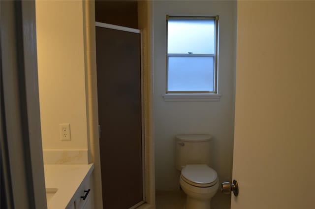 bathroom featuring vanity, toilet, and a shower with door