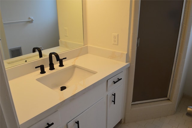 bathroom with tile patterned floors, vanity, and a shower with shower door