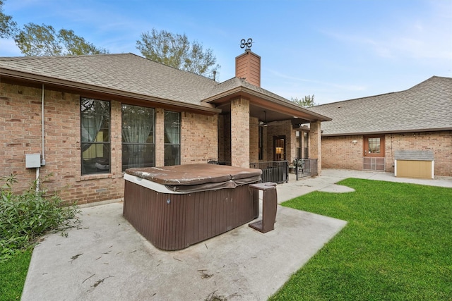 exterior space with a lawn, ceiling fan, a patio, and a hot tub