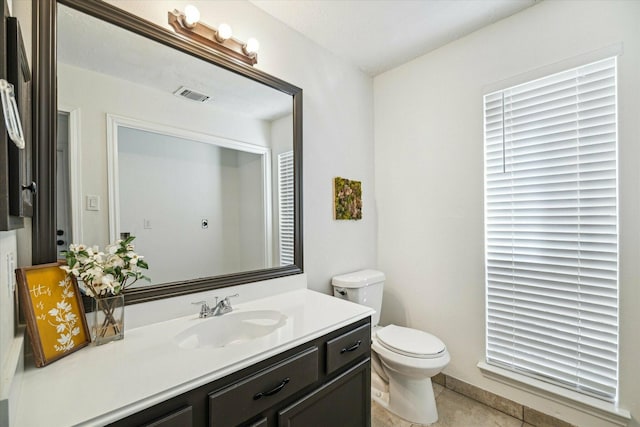 bathroom with tile patterned flooring, vanity, and toilet