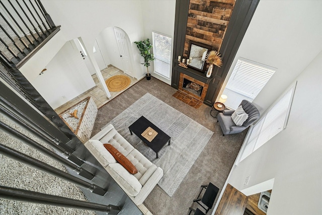 carpeted living room featuring a towering ceiling