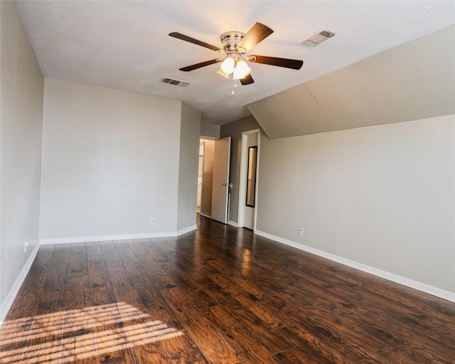 empty room featuring a textured ceiling, lofted ceiling, ceiling fan, and dark wood-type flooring