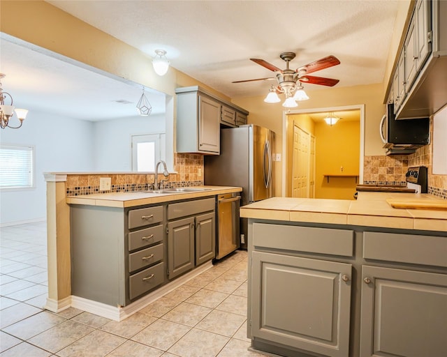 kitchen featuring gray cabinets, kitchen peninsula, and a healthy amount of sunlight