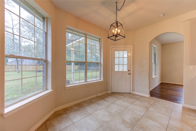 tiled foyer with a chandelier