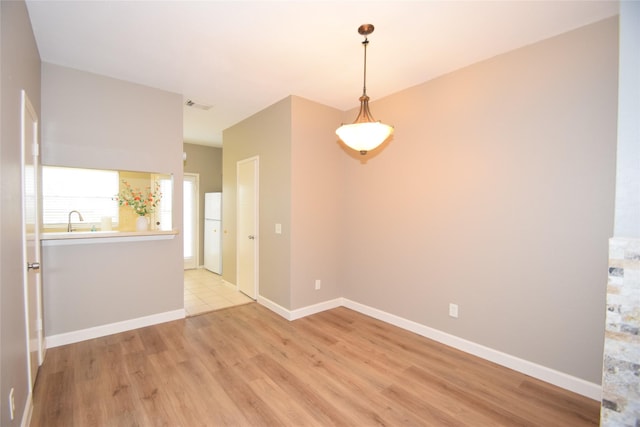 empty room with sink and light hardwood / wood-style flooring