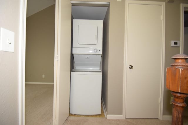 laundry room with light carpet and stacked washer and clothes dryer