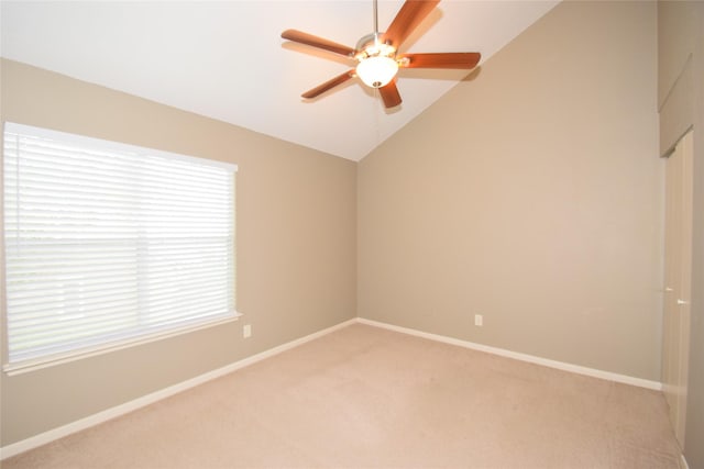 carpeted empty room with ceiling fan, a healthy amount of sunlight, and lofted ceiling