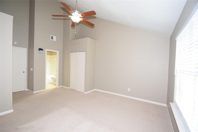 carpeted spare room with ceiling fan and high vaulted ceiling