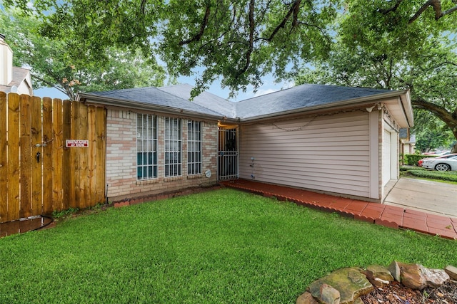 rear view of house with a yard and a garage