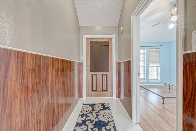 interior space with ceiling fan, light tile patterned floors, and a textured ceiling