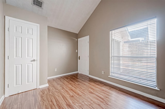 unfurnished bedroom with vaulted ceiling and light hardwood / wood-style flooring