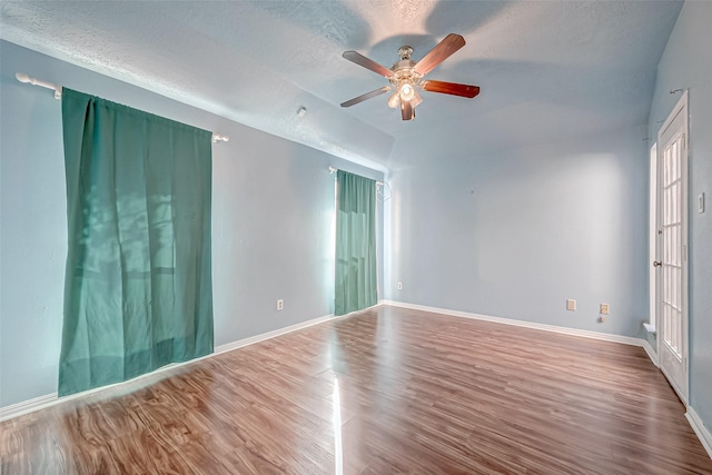 empty room with ceiling fan, hardwood / wood-style floors, and a textured ceiling