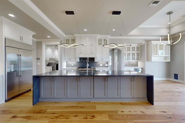 kitchen featuring white cabinetry, stainless steel built in fridge, and a large island