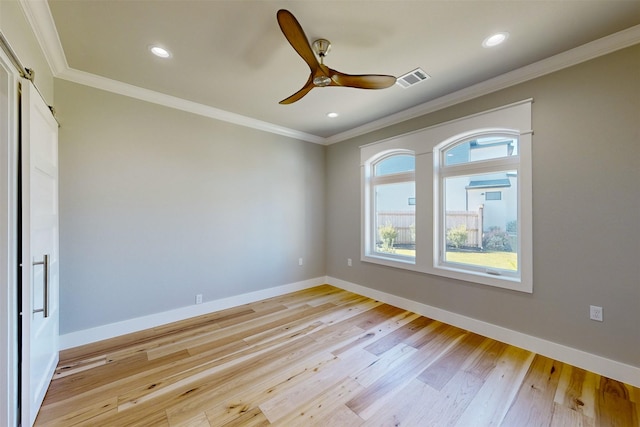 empty room featuring ceiling fan, light hardwood / wood-style floors, and crown molding