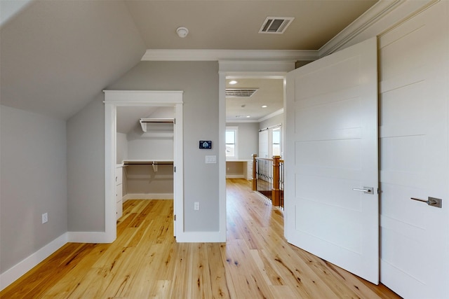 additional living space with light wood-type flooring and vaulted ceiling