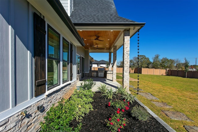 view of yard featuring ceiling fan, a patio area, and exterior kitchen