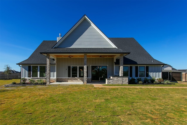 rear view of property featuring ceiling fan and a lawn