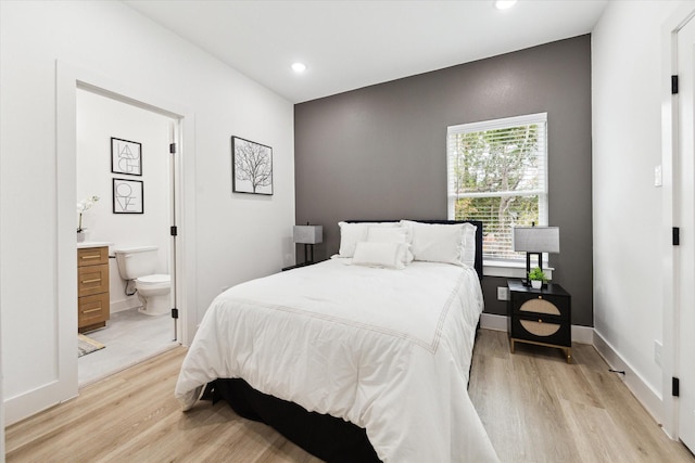 bedroom featuring light hardwood / wood-style flooring and ensuite bath