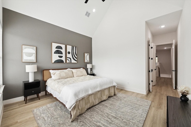 bedroom featuring high vaulted ceiling, light hardwood / wood-style flooring, and ceiling fan